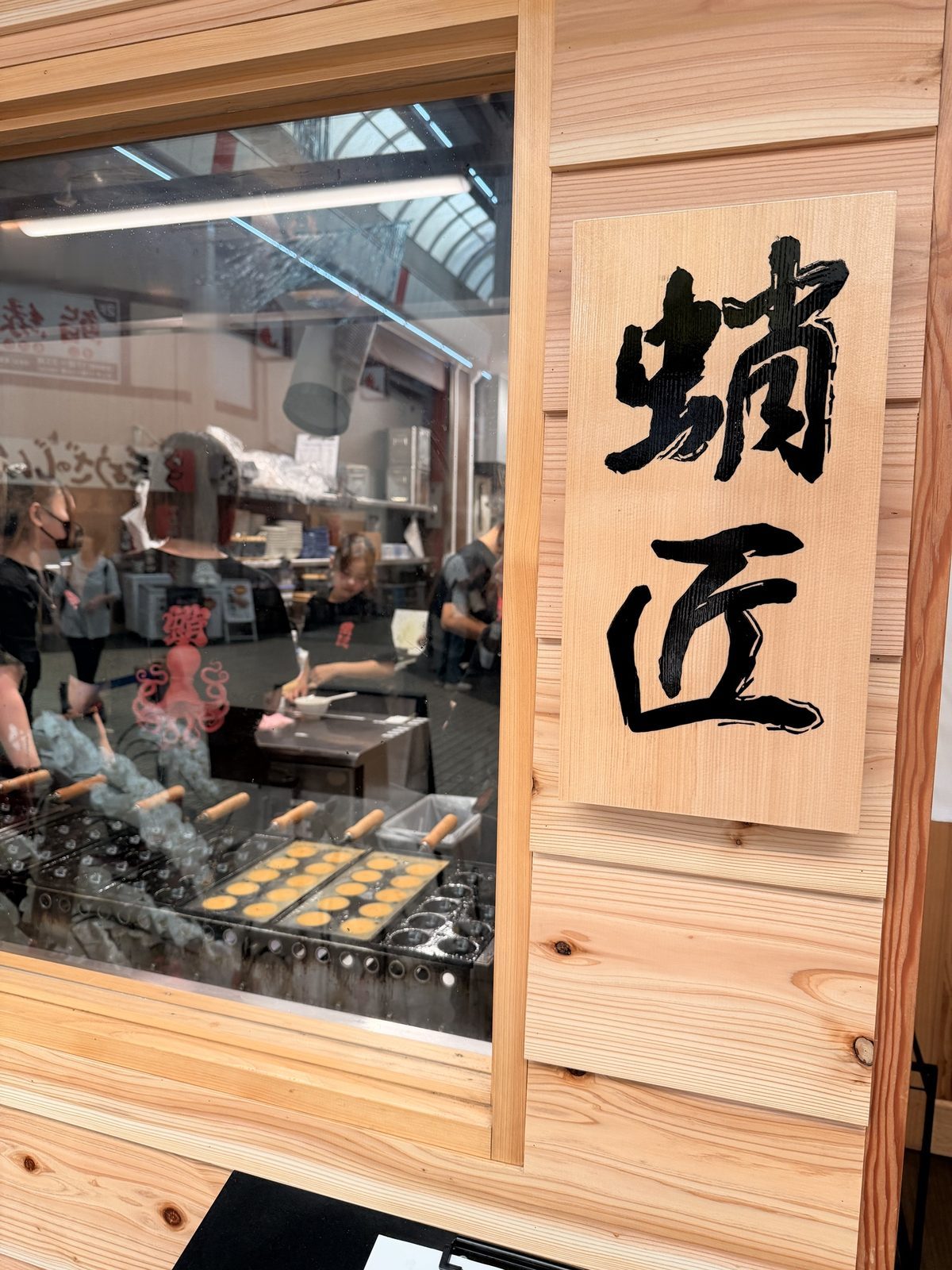 「蛸匠」の看板と、明石焼きを焼く様子