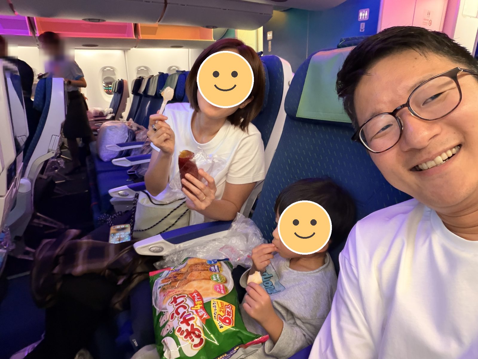 機内でおやつを食べる家族