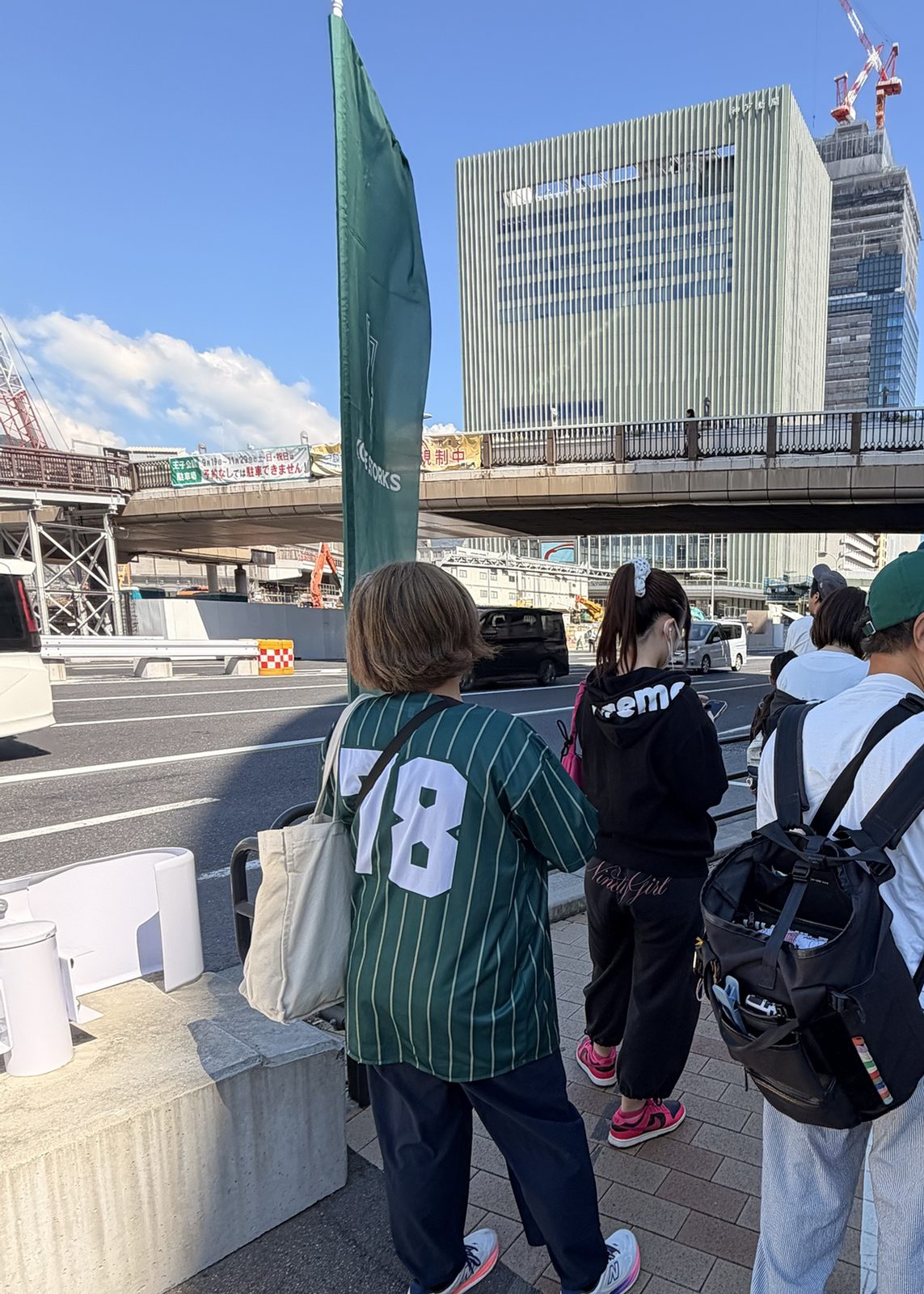 三宮駅前のバス乗り場の列。ストークスのユニフォーム姿の人も