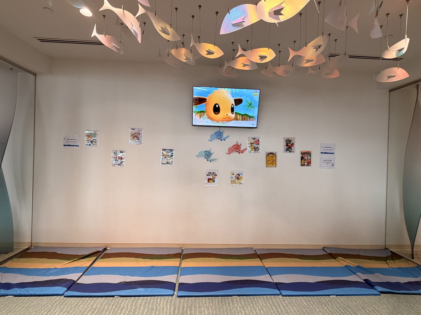 キッズスペースの中。マットとテレビ、天井には魚のモビール