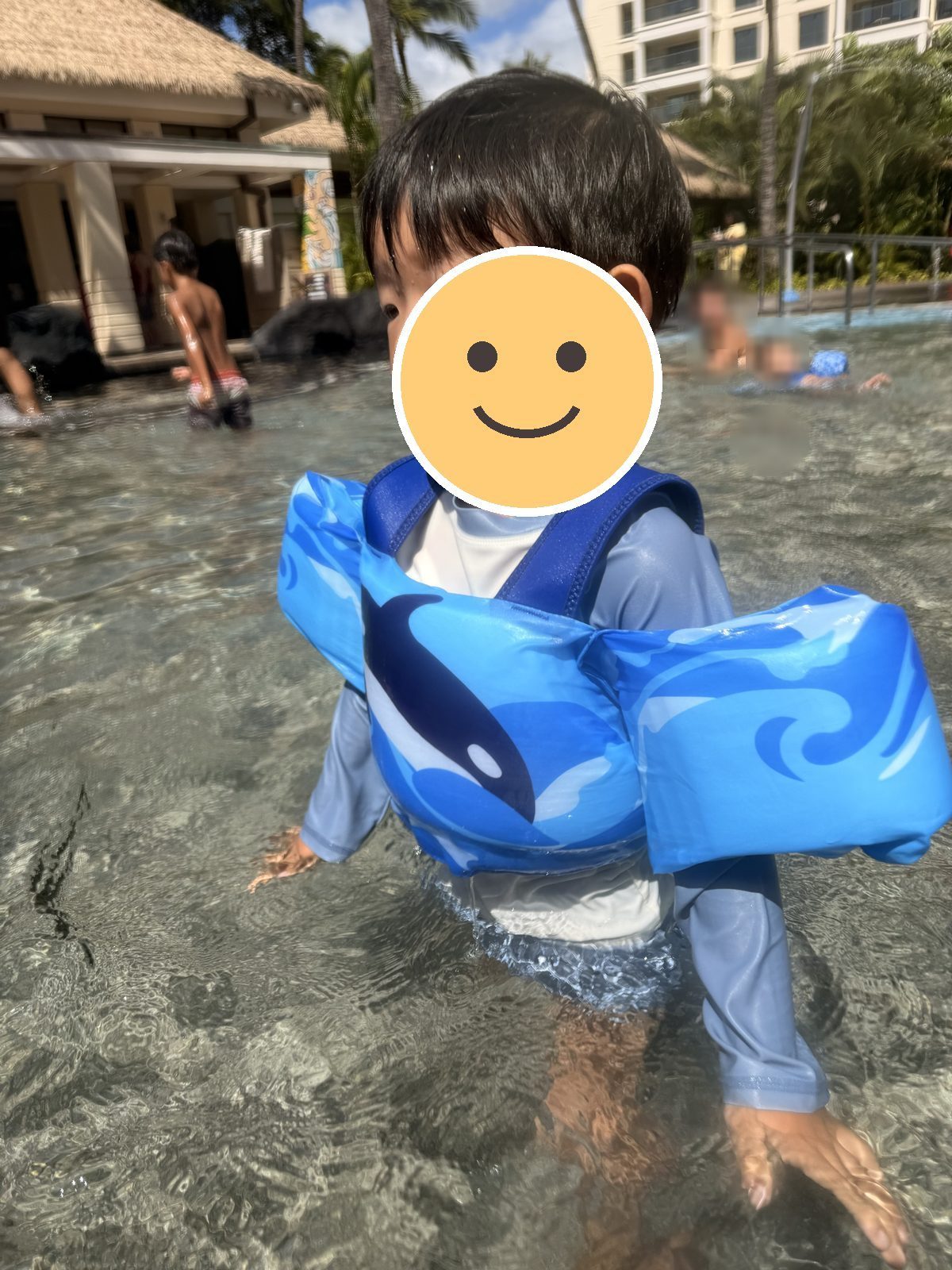 浮き輪のベストをつけてプールで遊ぶ息子