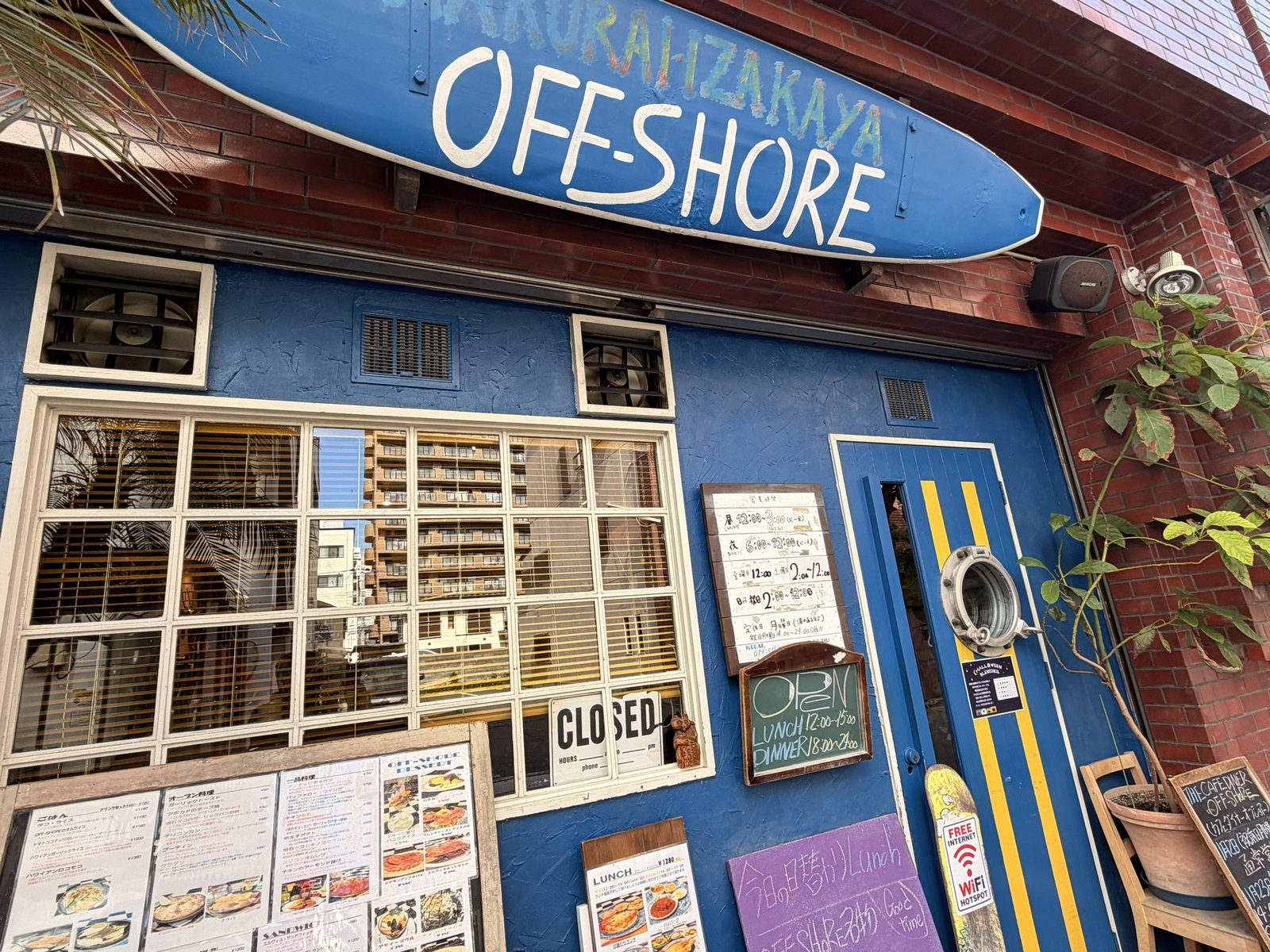 青い外観とOFF-SHOREのサーフボード看板