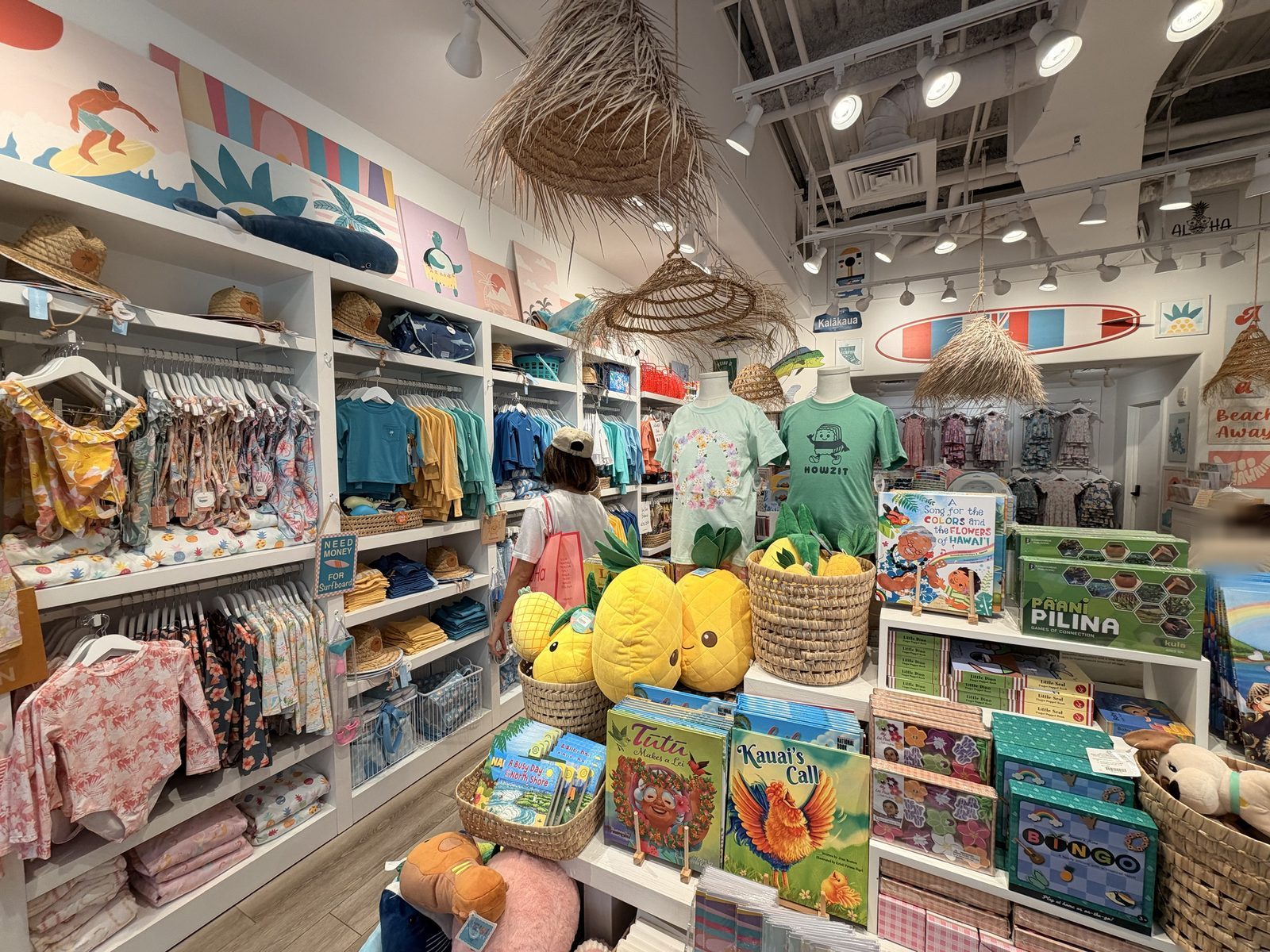 子ども服や絵本、パイナップルのぬいぐるみが並ぶ店内